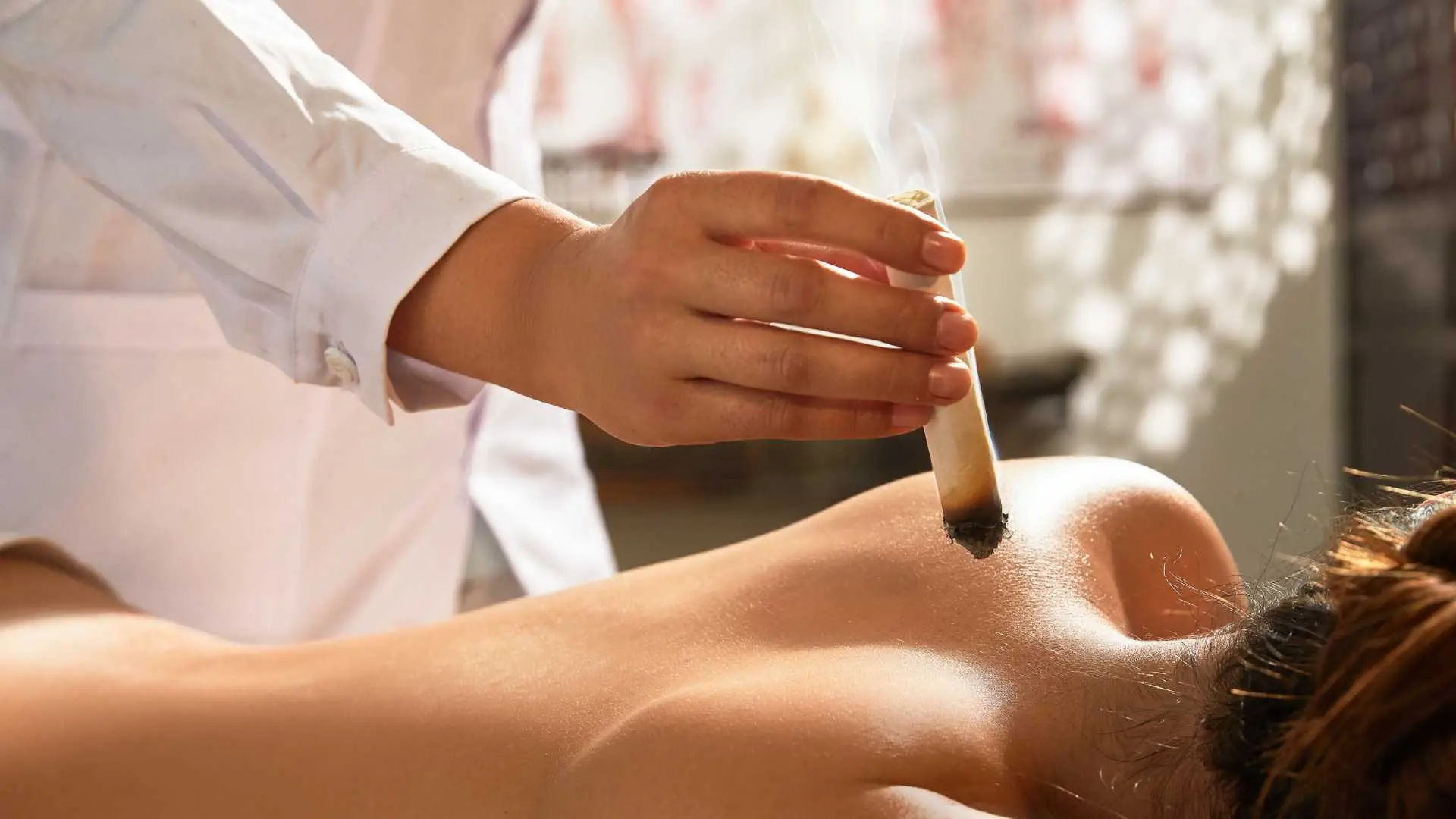 Aplicación de moxibustión en la espalda por terapeuta profesional en TAO Acupuntura