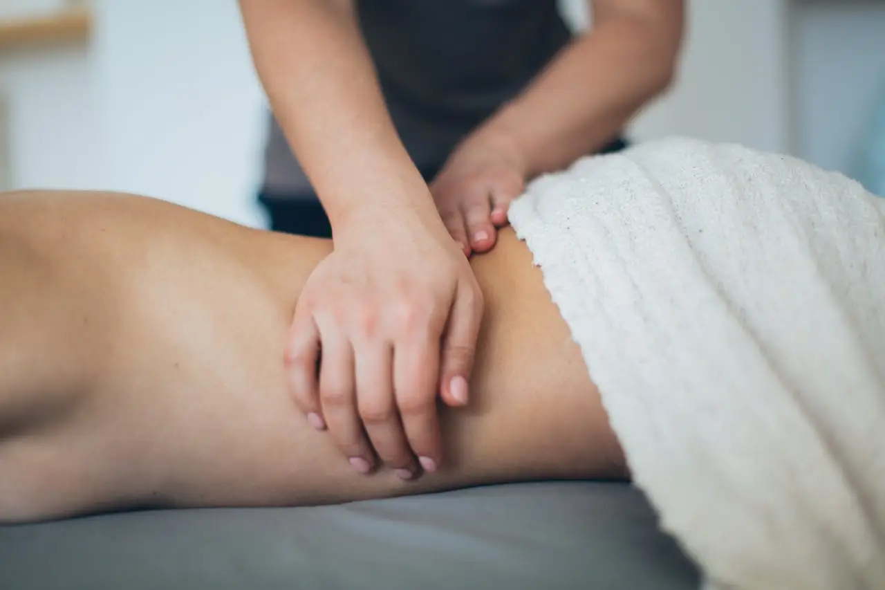 Manos de terapeuta aplicando masaje Tui Na en la espalda de un paciente
